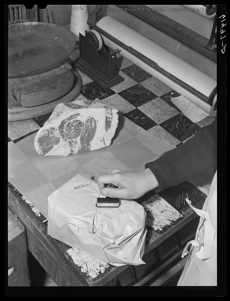 Stamping cut of meat before removing to freezing room. Cold storage locker, Casselton, North Dakota. Sourced from the…