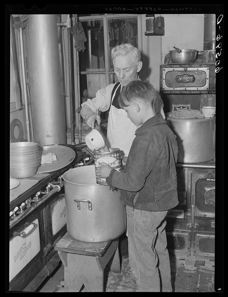 Young boy receiving pail of soup in kitchen of city mission. Dubuque, Iowa. Sourced from the Library of Congress.