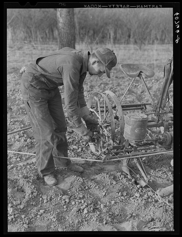 Adjusting wire on corn planter. Monona County, Iowa. Sourced from the Library of Congress.