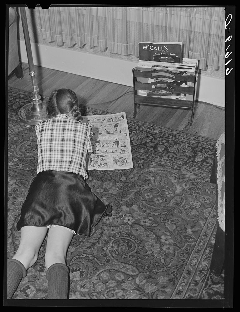 One of the Schulstead children reading funny papers. Aberdeen, South Dakota. Sourced from the Library of Congress.