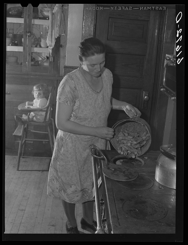 Mrs. Bettenhausen using corn cobs for fuel. McIntosh County, North Dakota. Sourced from the Library of Congress.