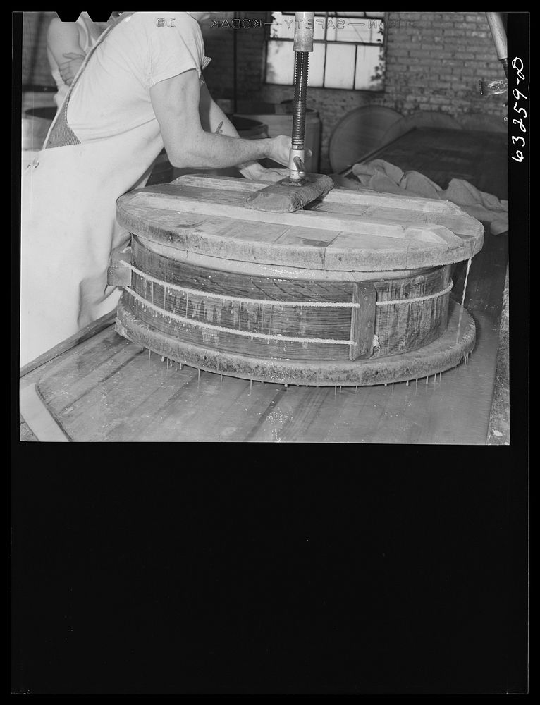 [Untitled photo, possibly related to: Pressing the curd into form. Swiss cheese factory. Madison, Wisconsin]. Sourced from…
