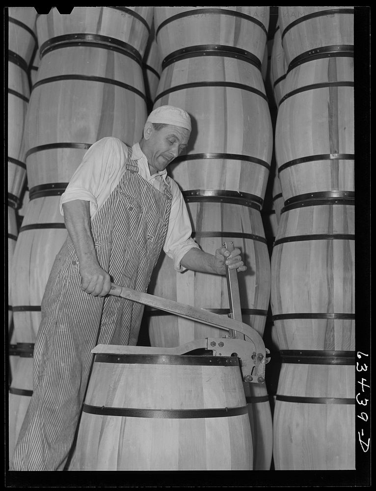 Clamping top on barrel of powdered milk. Milk condensary, Antigo, Wisconsin. Sourced from the Library of Congress.