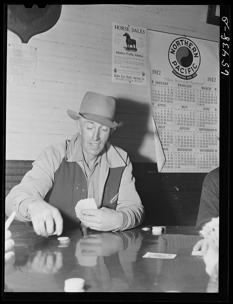 Wisdom, Montana. Walt Stewart in card game on Saturday afternoon. Mr. Stewart is a rancher who owns about 500 head of…