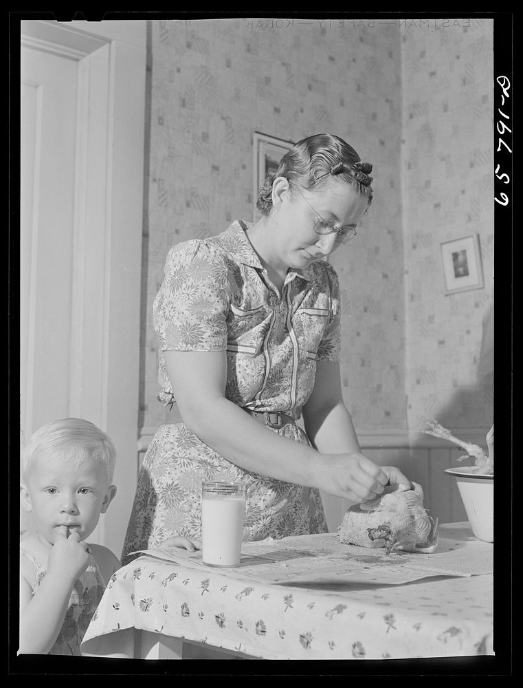 Lancaster County, Nebraska. Mrs. Lynn May, FSA (Farm Security Administration) borrower, cleaning a chicken. Sourced from the…
