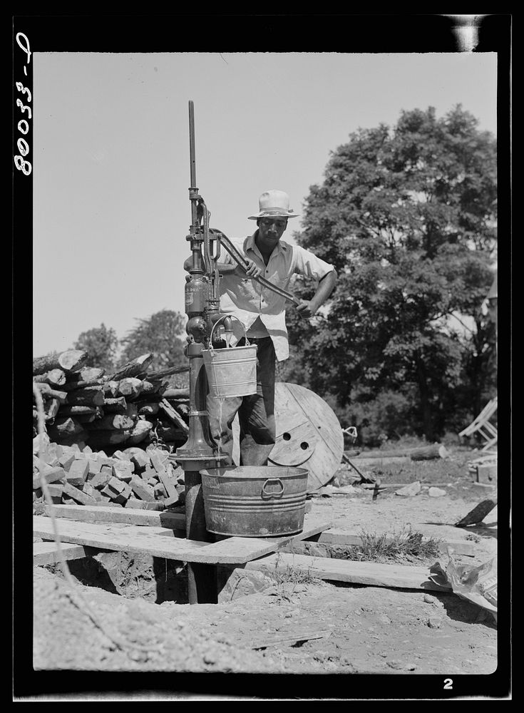 The first bucket of water is pumped. John Fredrick well project, Saint Mary's County, Maryland. Sourced from the Library of…