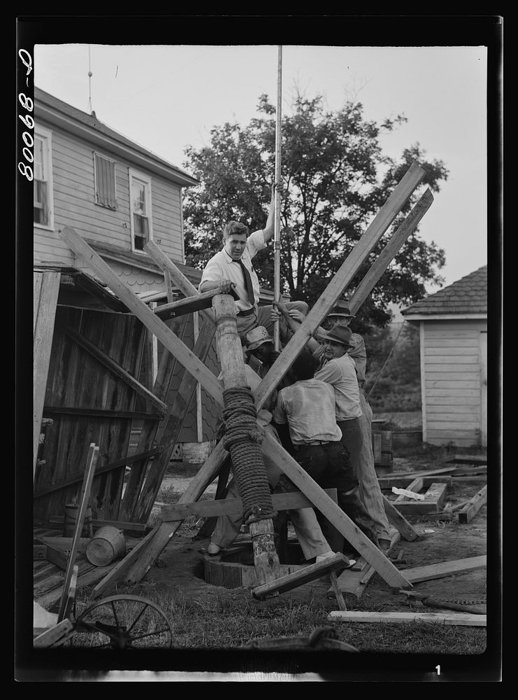[Untitled photo, possibly related to: Pump is lowered on pump rod and casing before settling drop pipe in place. Long well…