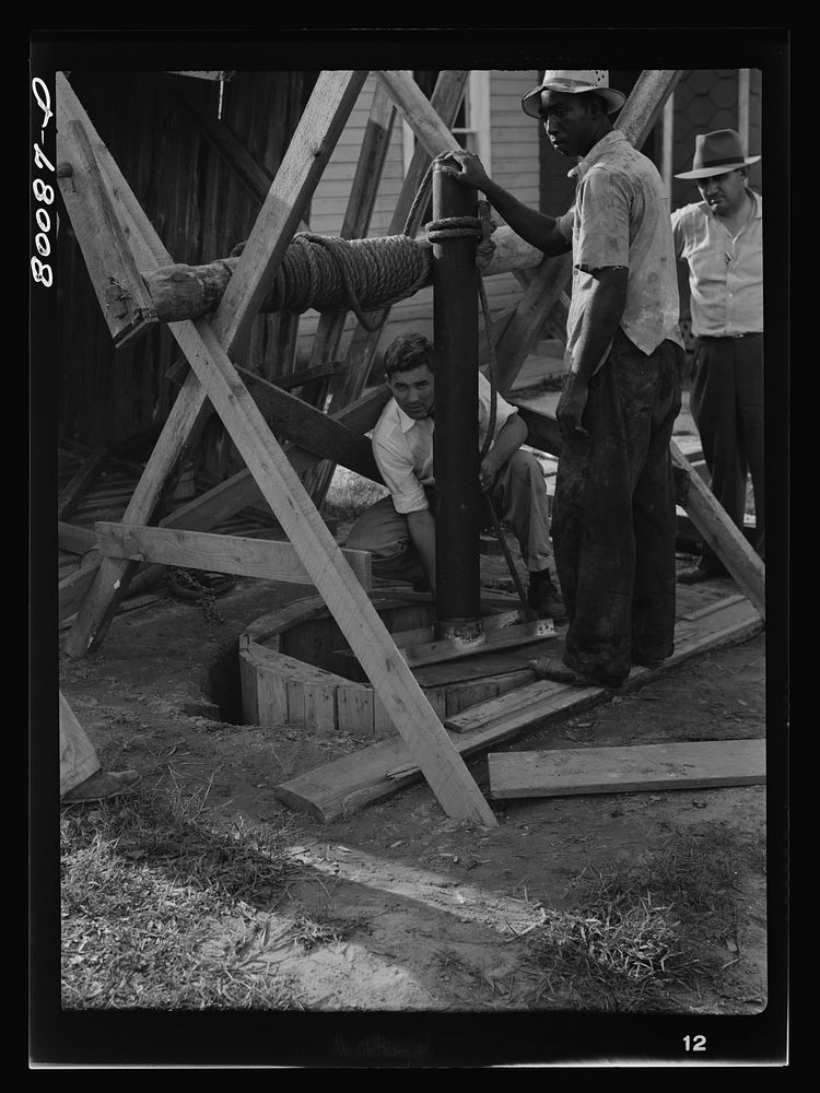 Placing the first piece of casing over the concrete culvert pipe. Safe well demonstration near La Plata, Maryland. Charles…