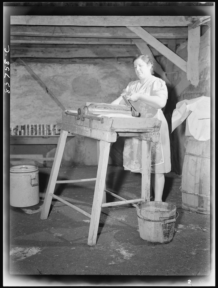 Fort Kent, Maine (vicinity). Mrs. [Leonard] Gagnon wringing water out of butter after salting. Sourced from the Library of…