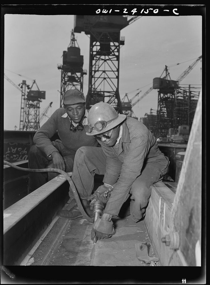Baltimore, Maryland. A chipper removing excess metal from a welded seam during the construction of the Liberty ship…