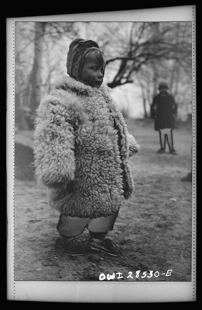 Teheran, Iran. Little Polish girl in a big sheepskin coat who is at an evacuation camp operated by the Red Cross. Sourced…