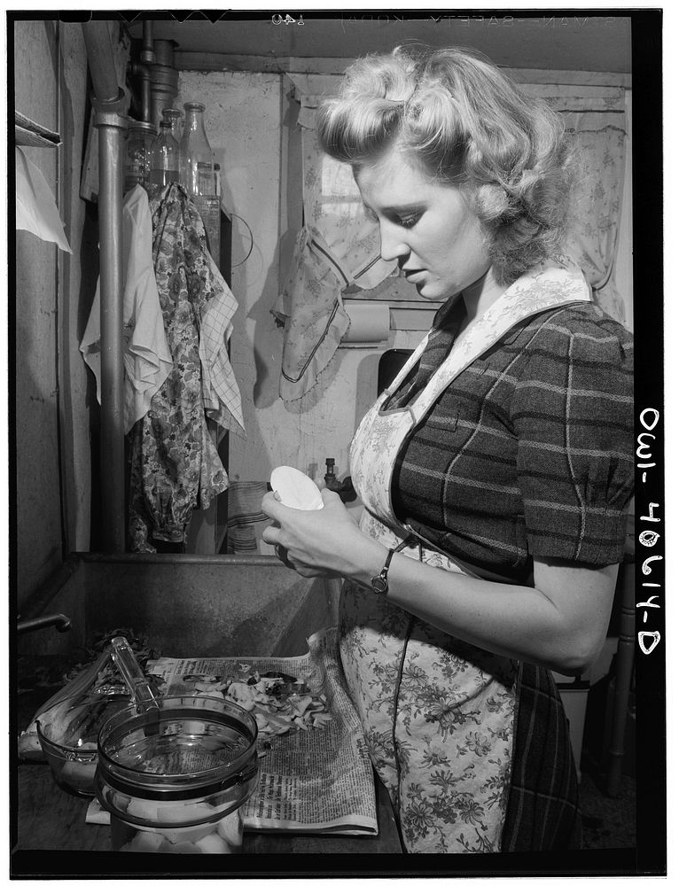 Washington, D.C. Lynn Massman, wife of a second class petty officer who is studying in Washington, preparing dinner. Sourced…