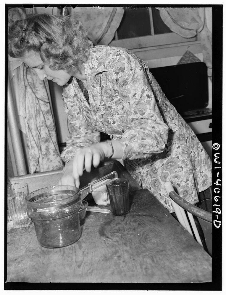 Washington, D.C. Lynn Massman, wife of a second class petty officer who is studying in Washington, does the breakfast dishes…