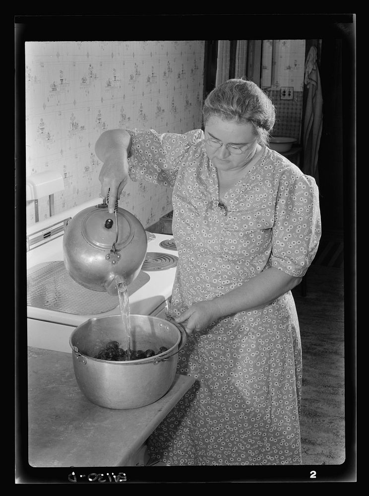 After washing and sorting, Mrs. Wright Hendricks blanches prunes. Sourced from the Library of Congress.