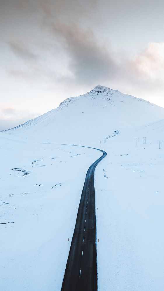 Nature phone wallpaper background, long black road on the white winter landscape