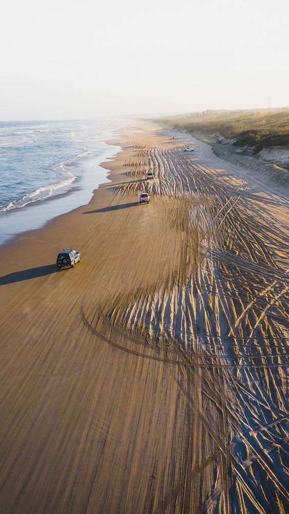 Adventure mobile wallpaper background, cars driving on a beach