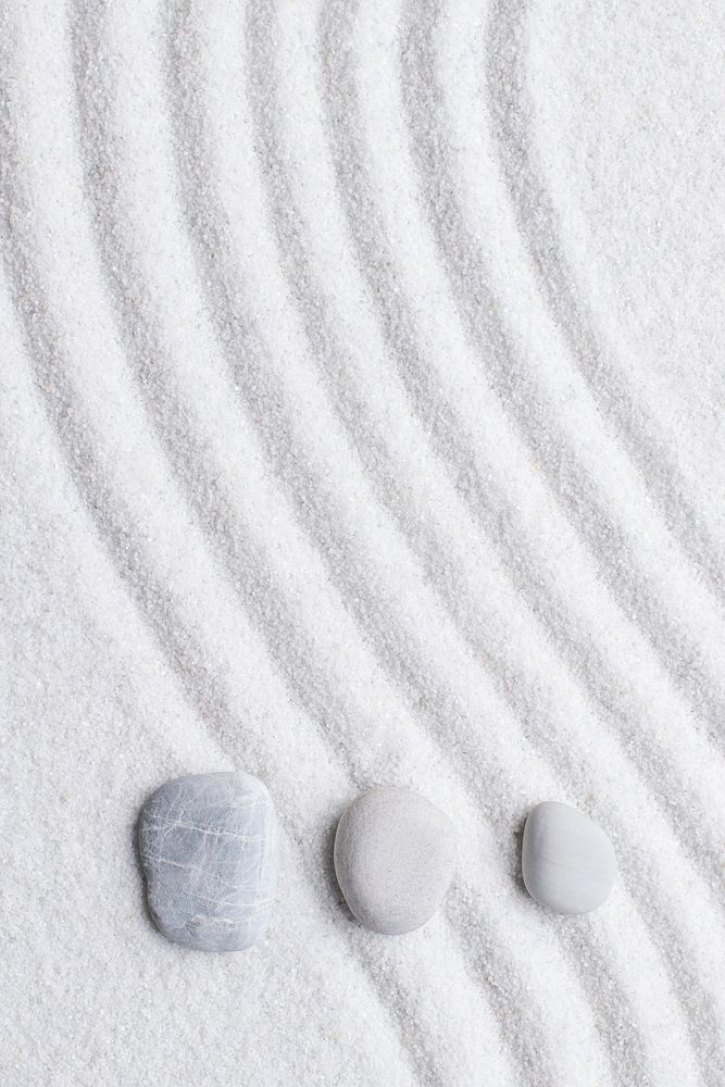 Zen stones white sand background in art of balance concept