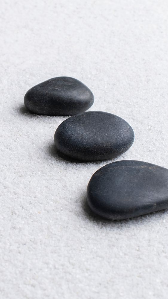 Black zen stones stacked on white background in wellness concept