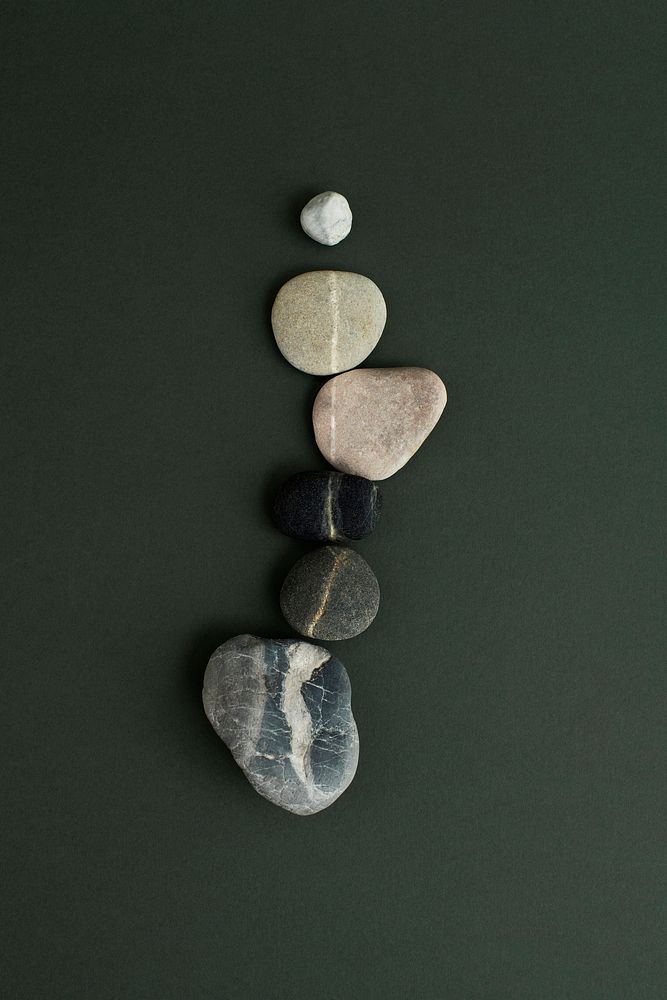 Zen stones stacked on green background in health and wellbeing concept