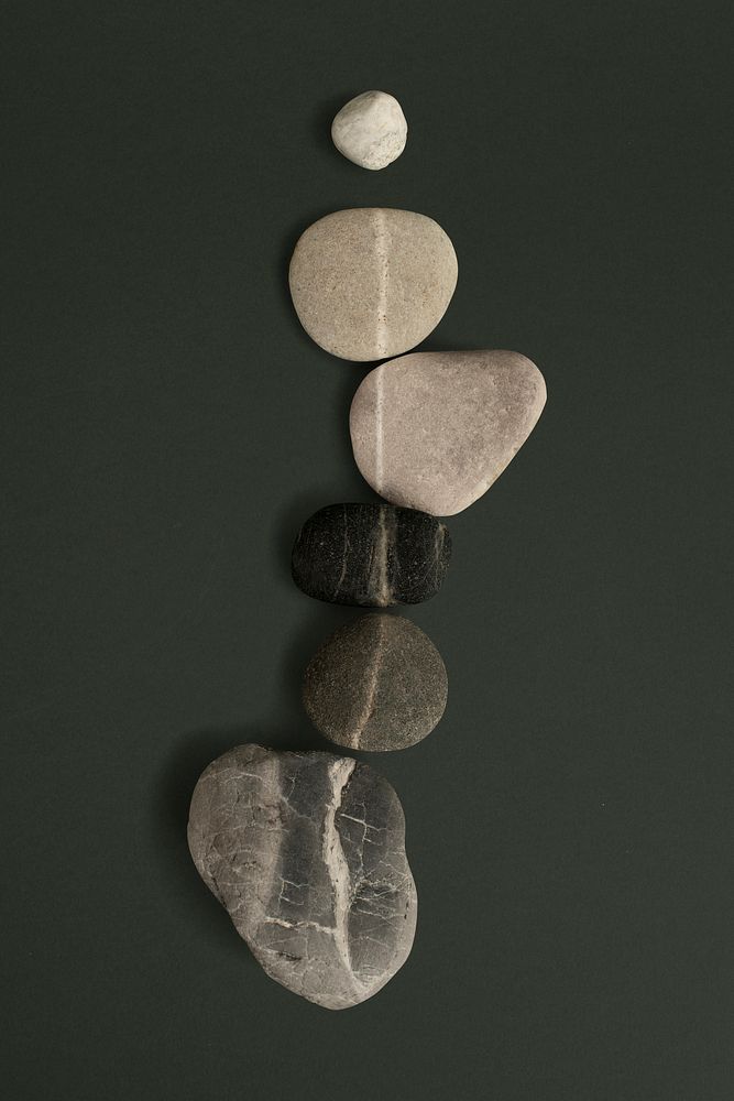 Zen stones stacked on green background in health and wellbeing concept