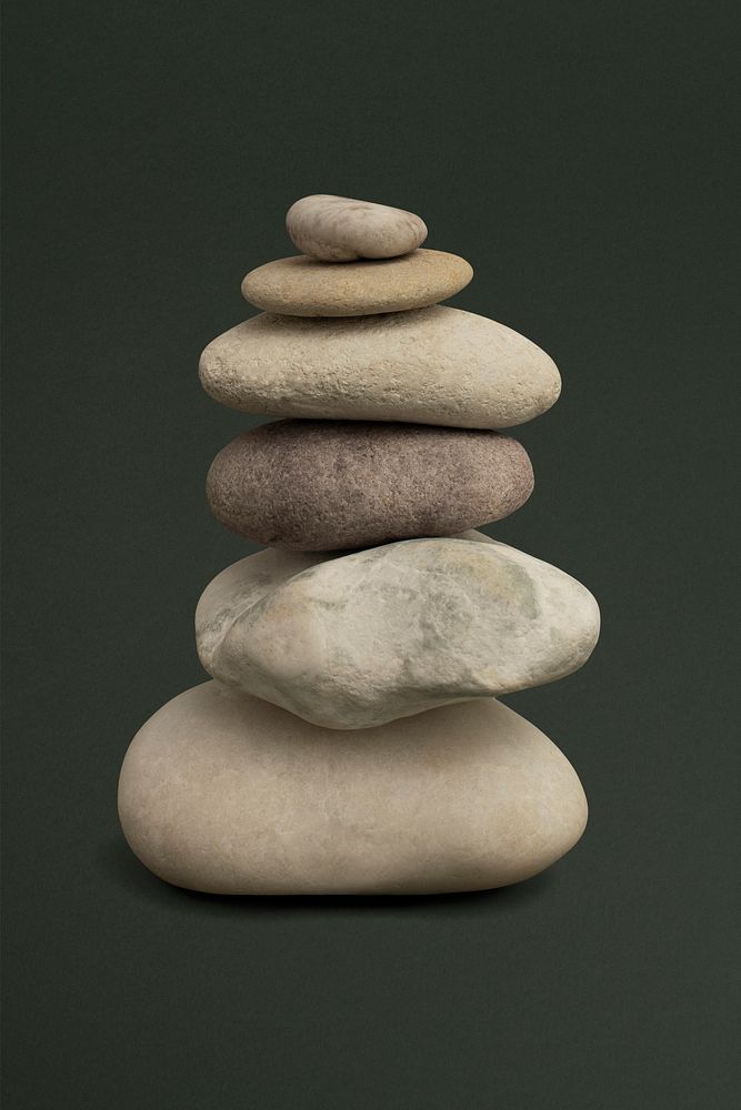 Marble zen stones stacked on green background in stability concept