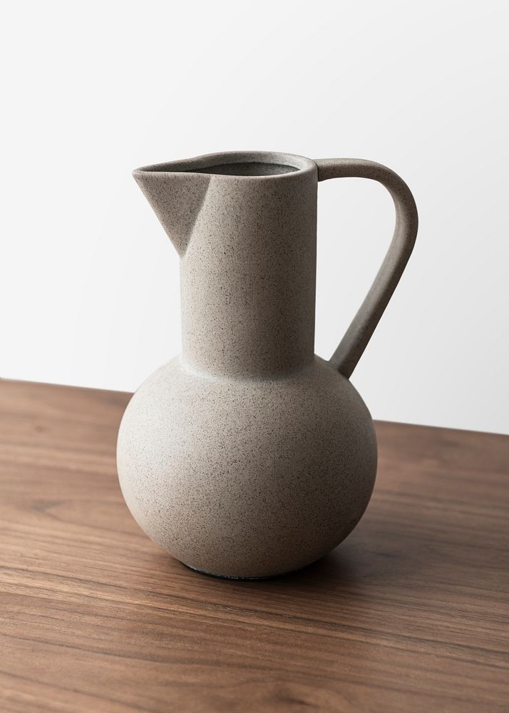 Black textured ceramic jug vase on a wooden table