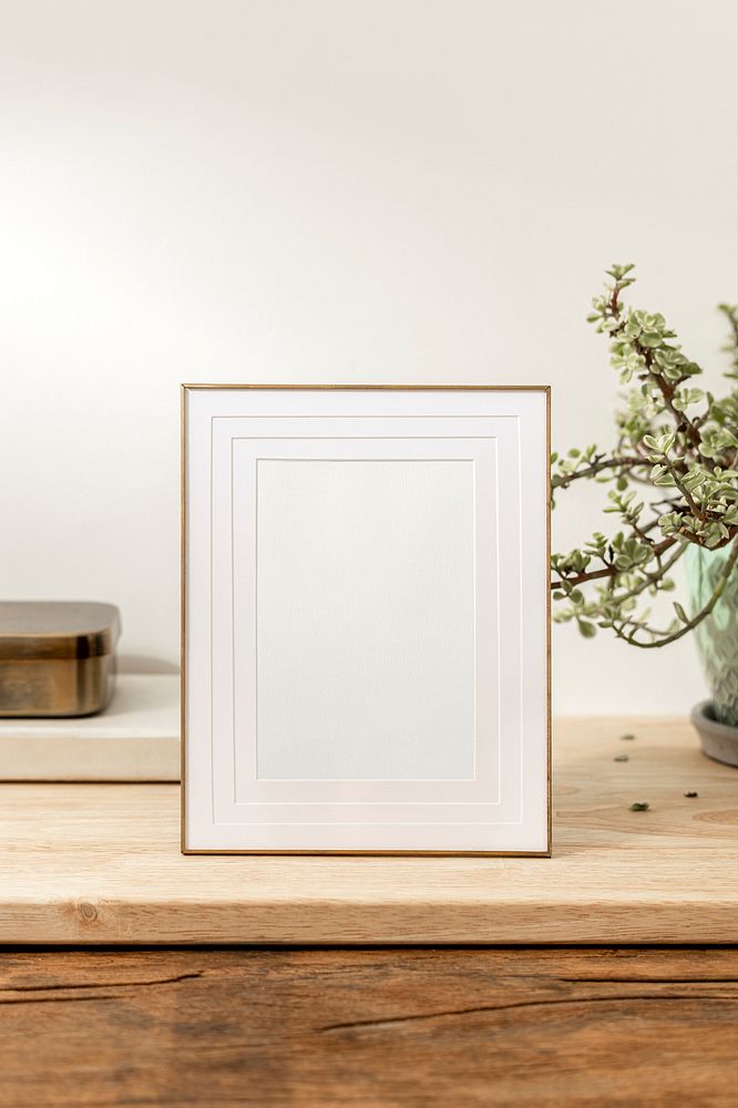 Blank decorative picture frame on wooden table