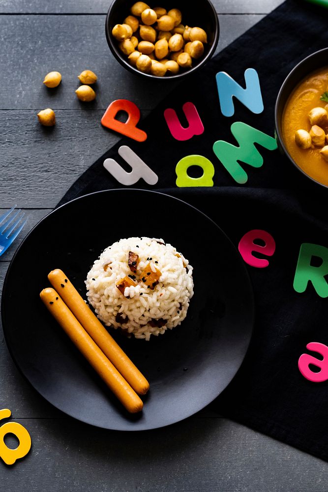 Kids Halloween party food with pumpkin risotto and frankfurters