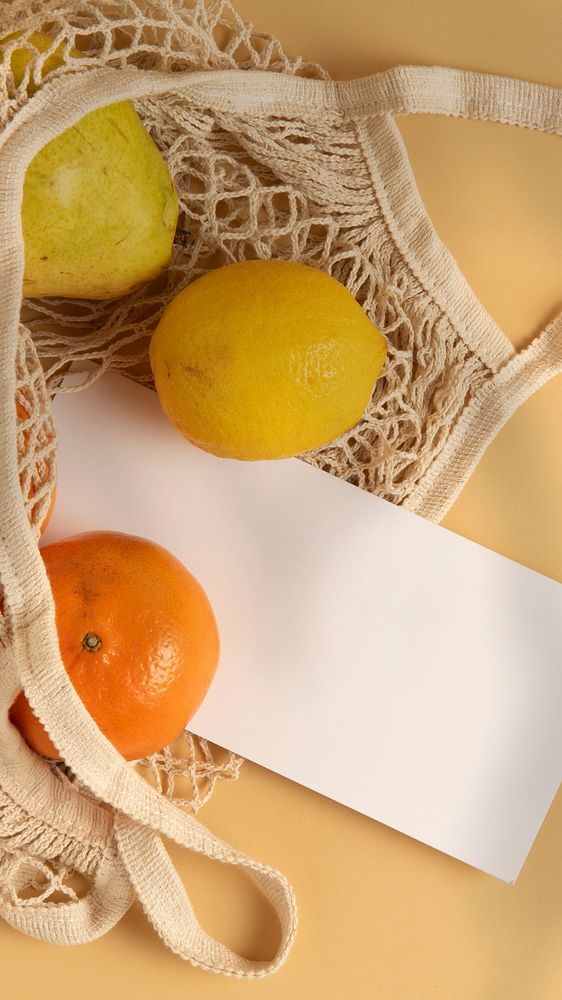 Mobile wallpaper background, orange and lemon in a net shopping bag