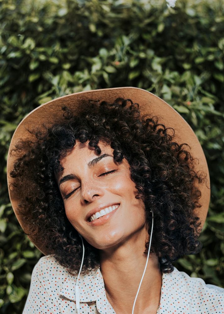 Woman with curly hair wearing earphones remixed media