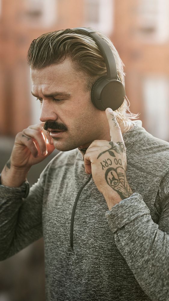 Handsome man wearing wireless headphones remixed media