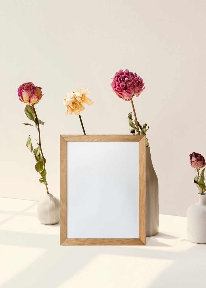 Frame with flowers against white minimal wall 