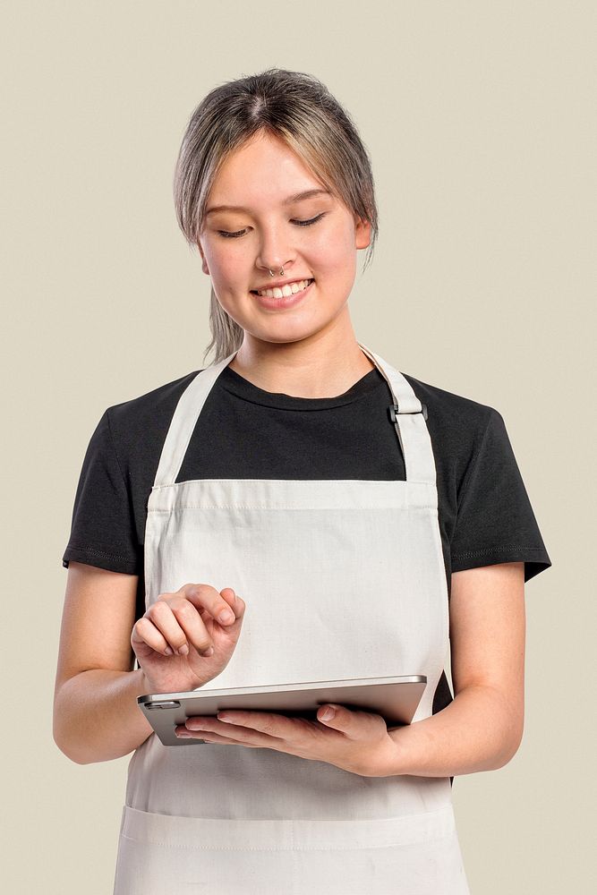 Young in apron woman using tablet