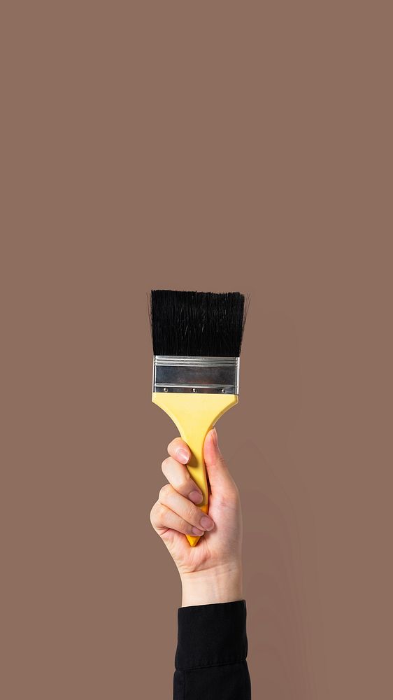 Hand holding brush mockup psd for wall painting