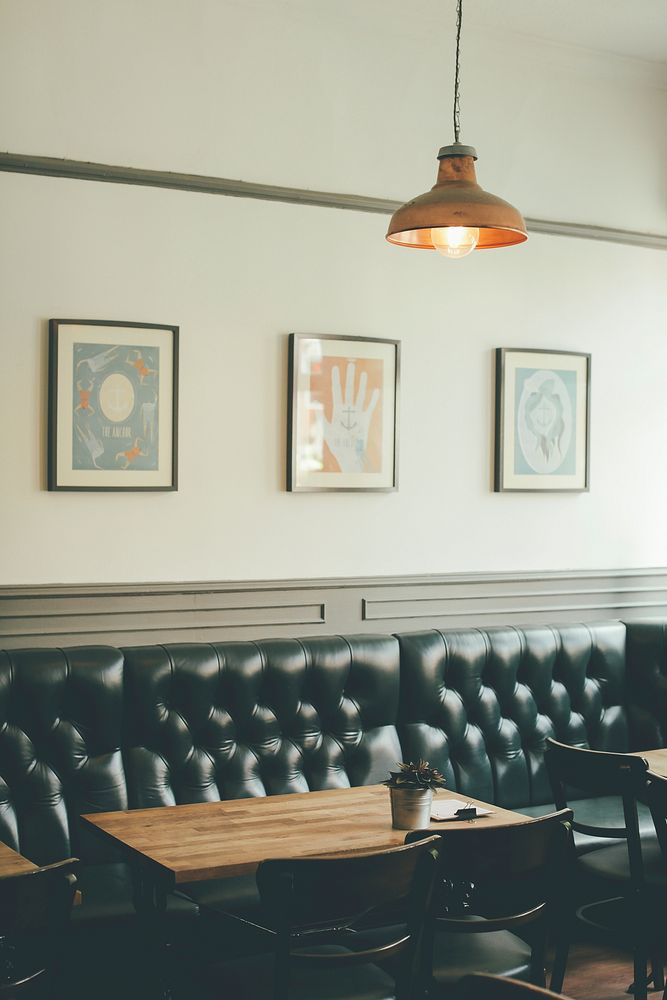 Tables next to padded leather sofa in a café. Original public domain image from Wikimedia Commons