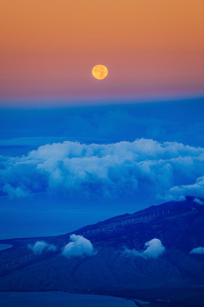 Moonrise on a cloudy blue sky at dawn. Original public domain image from Wikimedia Commons