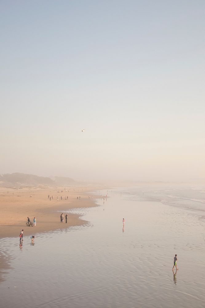People on sand, sunset coastline. Original public domain image from Wikimedia Commons