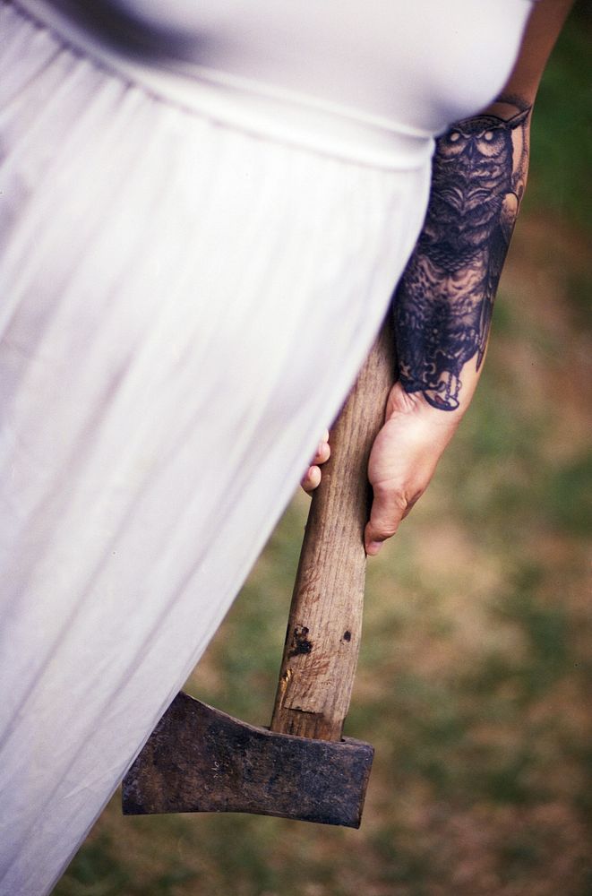 A lady in a white dress holding a rusty axe.. Original public domain image from Wikimedia Commons