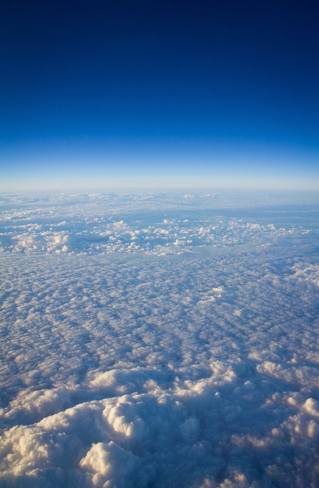 Aeriel view of clouds with blue sky in the distance. Original public domain image from Wikimedia Commons