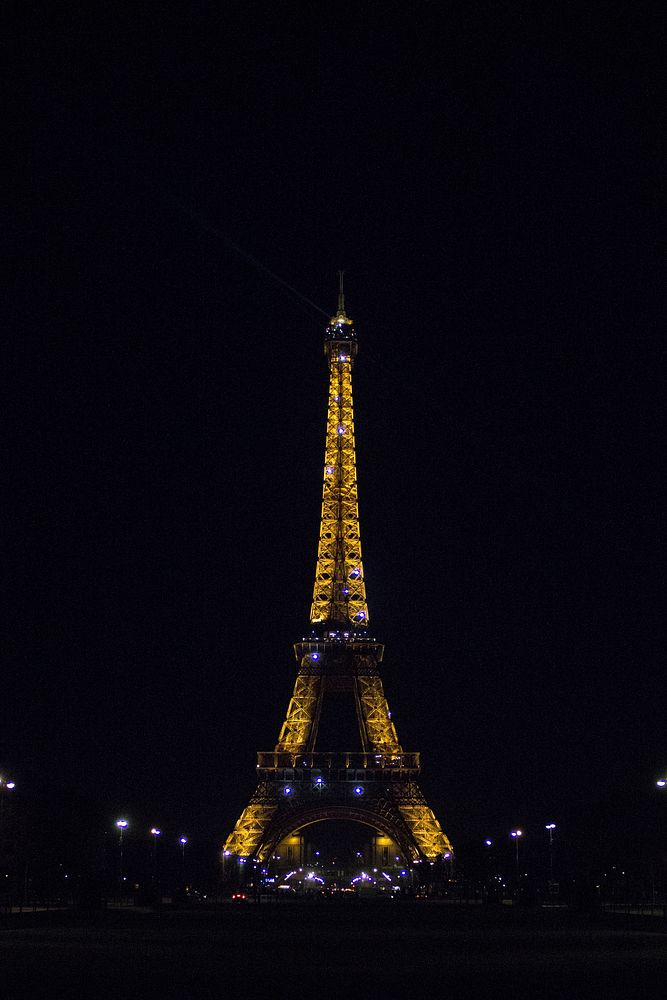 A complete view of the Eiffel Tower illuminated at night in Paris. Original public domain image from Wikimedia Commons
