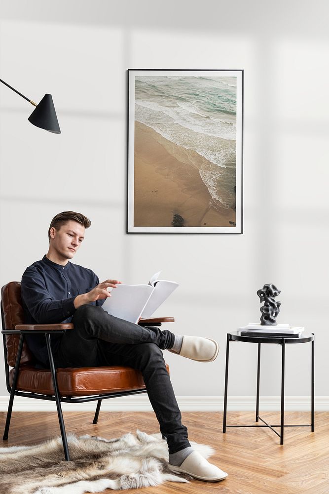 Young man reading a report in a cozy reading room while working from home