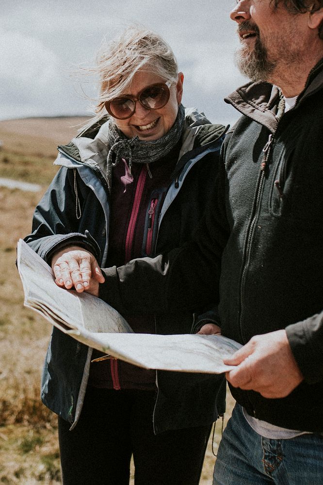 Senior tourist couple looking at the map while being lost in Wales, UK