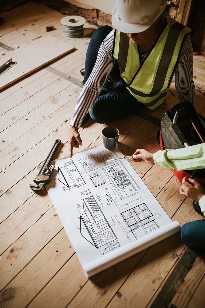 Contractors reading floor plan at a construction site