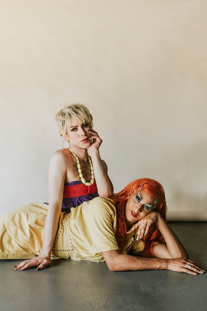 Drag show artists sitting on a floor