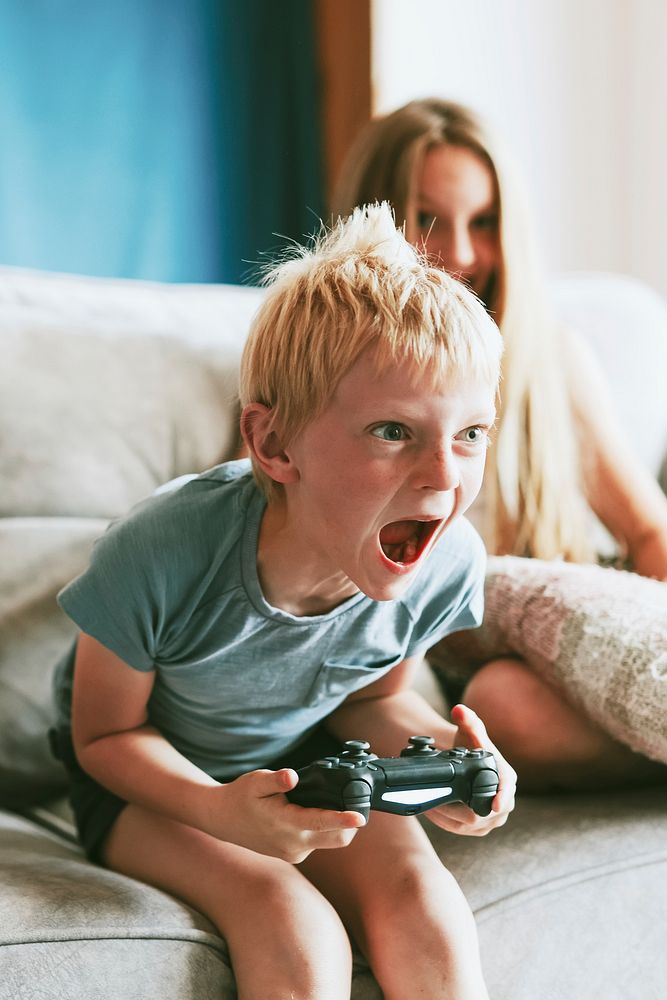 Young boy playing video game in living room