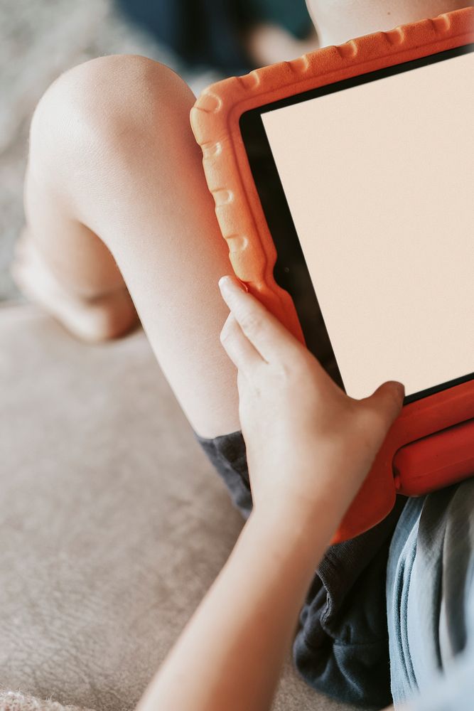 Blond boy learning online with digital tablet