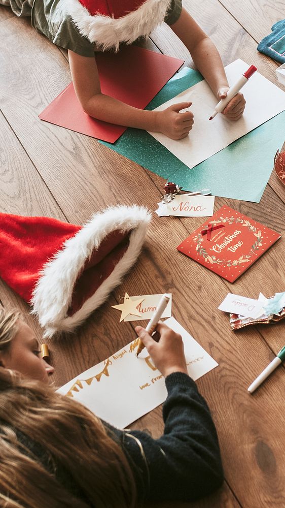 Christmas phone wallpaper, kids writing Christmas cards on wooden floor