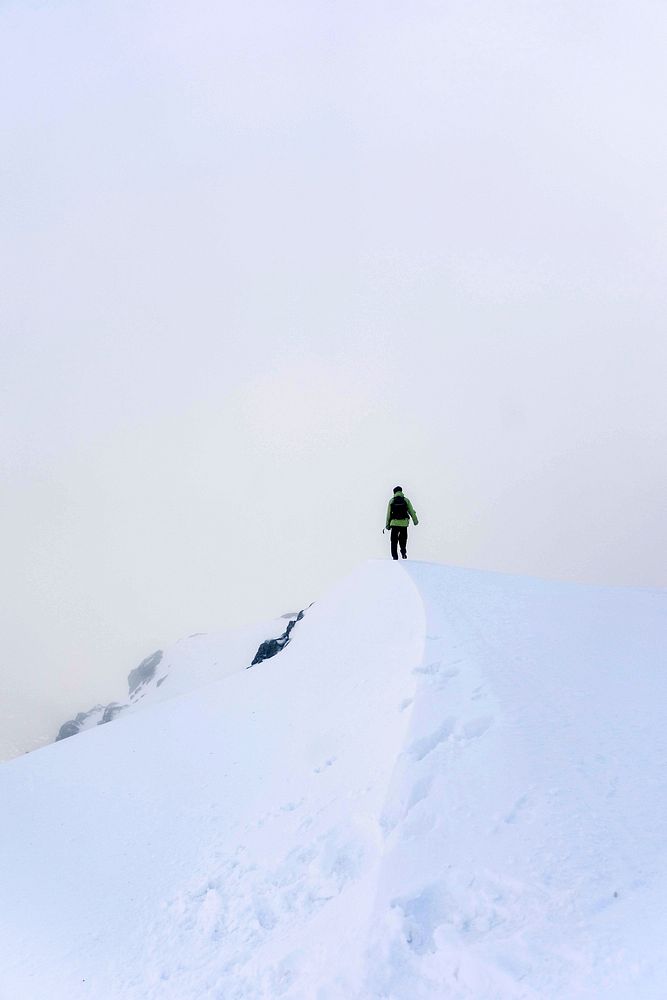 Man standing on a snow-covered Carnedd Dafydd mountain peak in Snowdonia