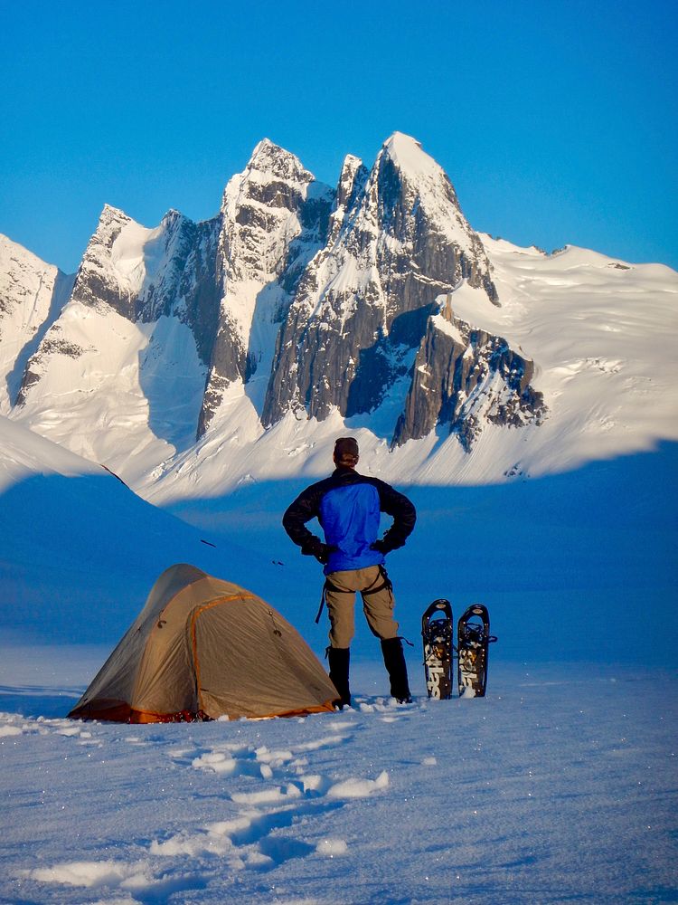 Man camping on a snowy mountain. Original public domain image from Flickr