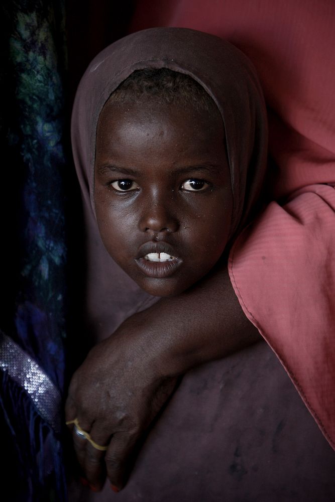A young Somali girl waits inside a tent where Ugandan soldiers and doctors serving with the African Union Mission in Somalia…